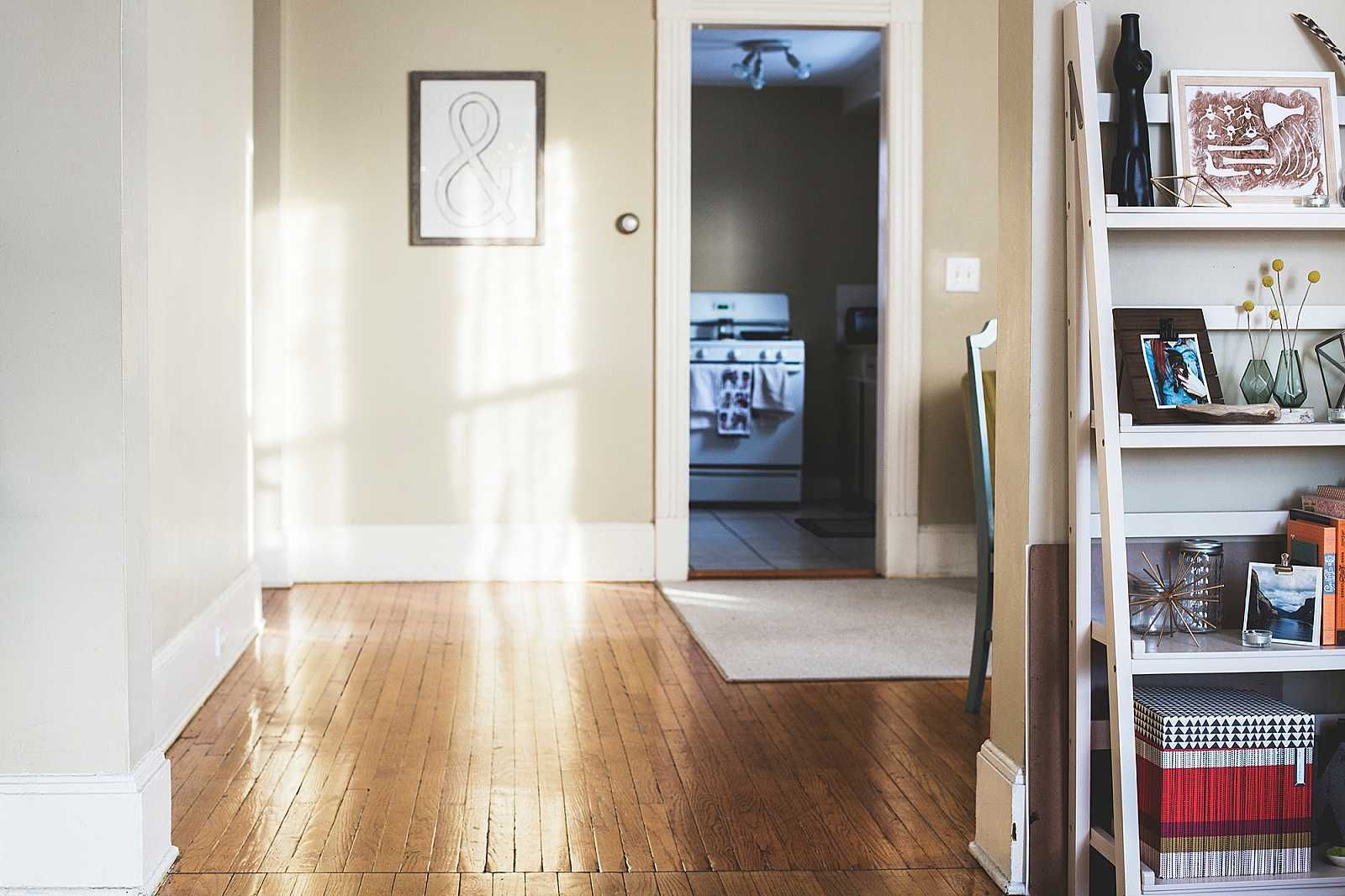 A living room with hardwood floors and a shelf full of books