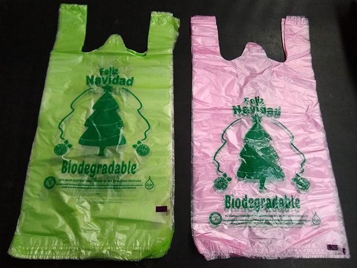 Dos bolsas de plástico biodegradables con árboles de Navidad en ellas.
