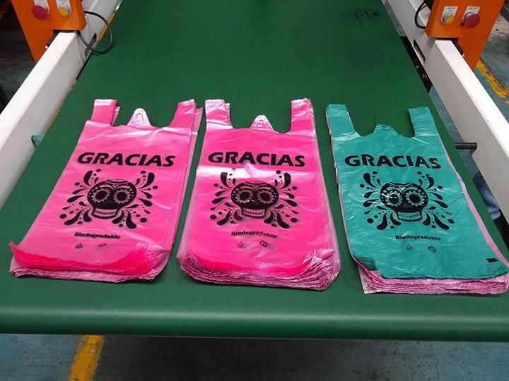 Tres bolsas de plástico que dicen gracias están en una cinta transportadora