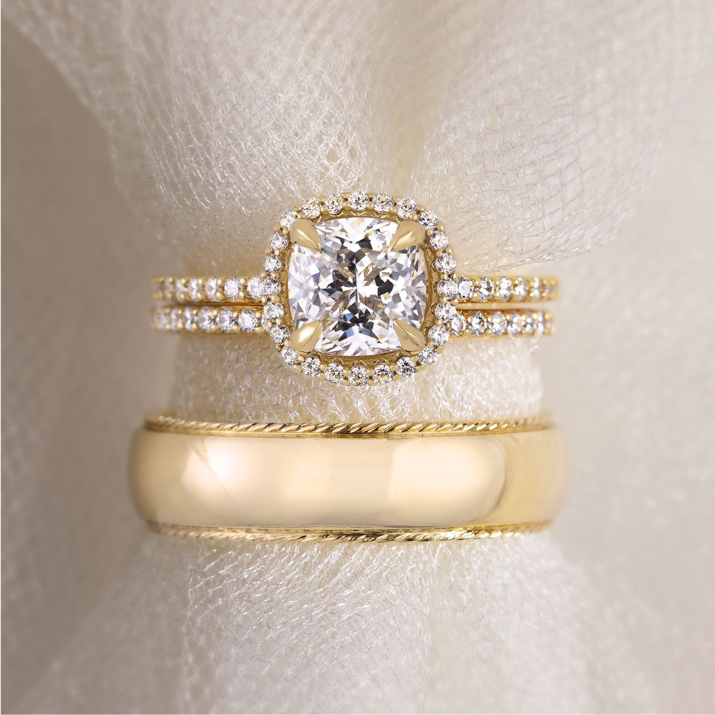 A close up of a wedding ring and engagement ring on a napkin.