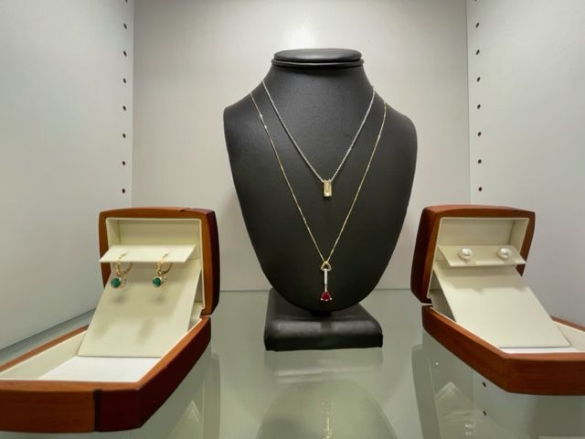 A mannequin with a necklace and earrings on it