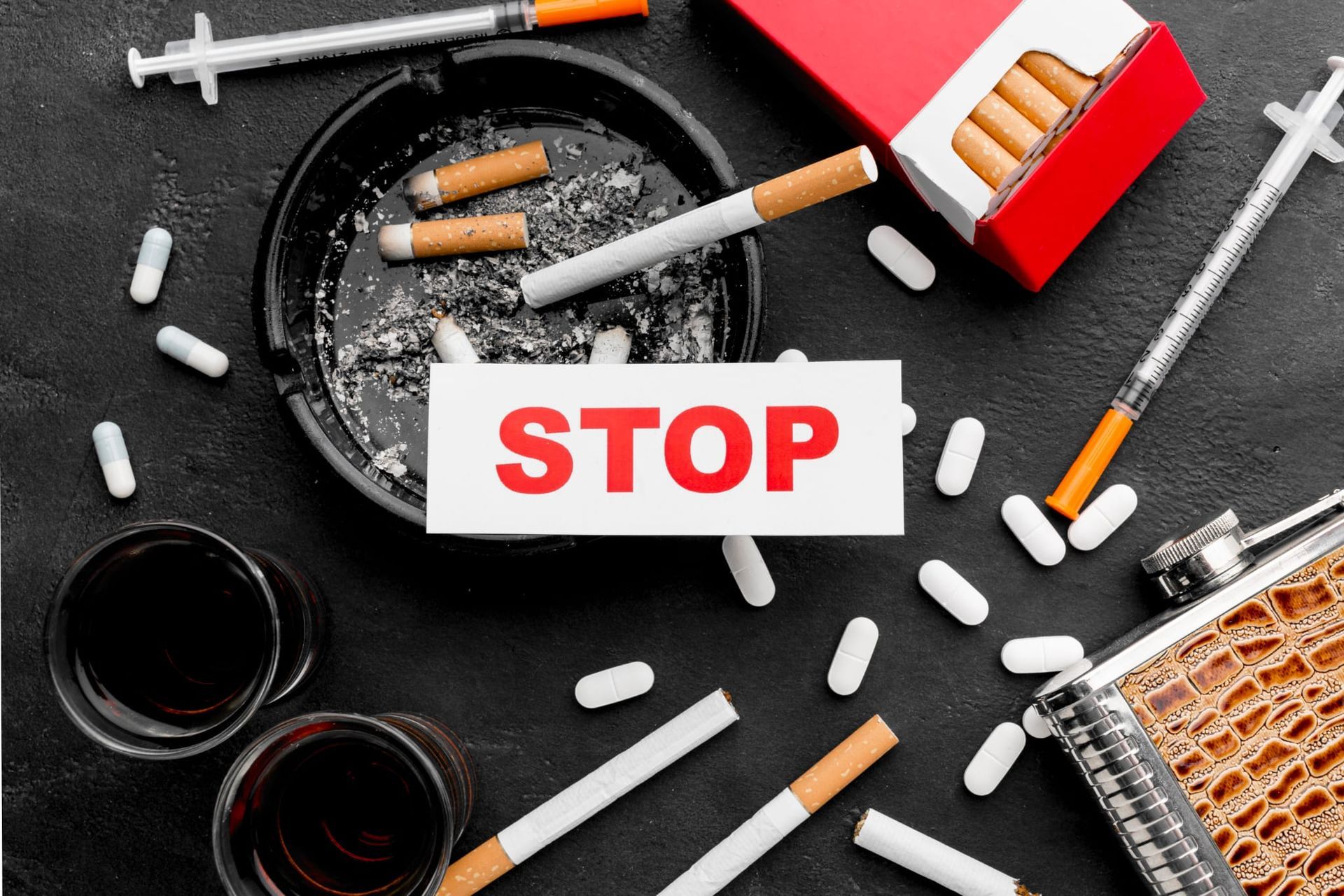 cigarettes, d'alcool, de pilules et de seringues avec panneau STOP, message contre la toxicomanie