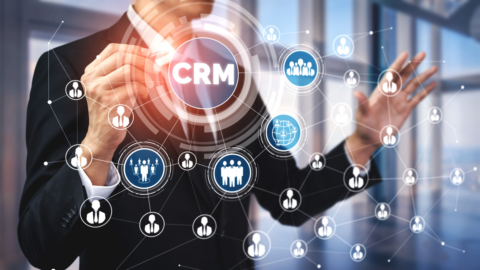 A man in a suit is touching a screen with the word crm on it.