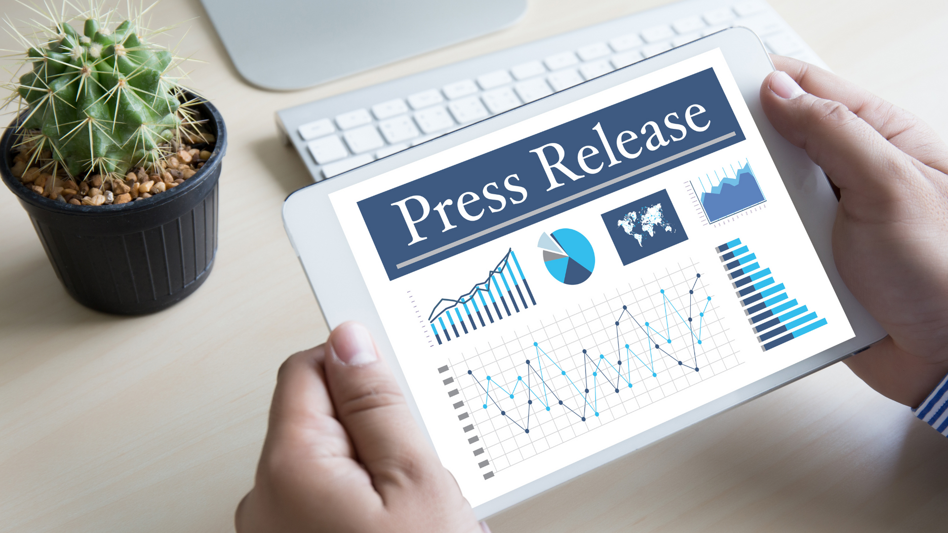A person is holding a tablet with a press release on it.
