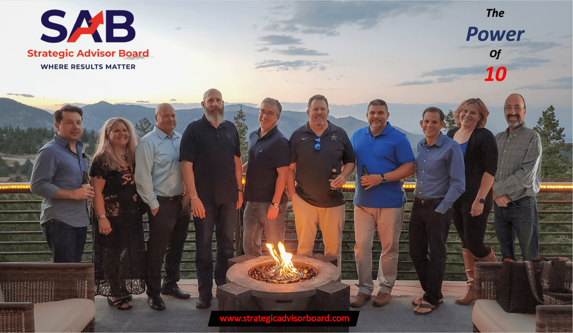 A group of people are posing for a picture in front of a fire pit.