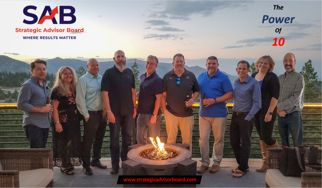 A group of people are posing for a picture in front of a fire pit.