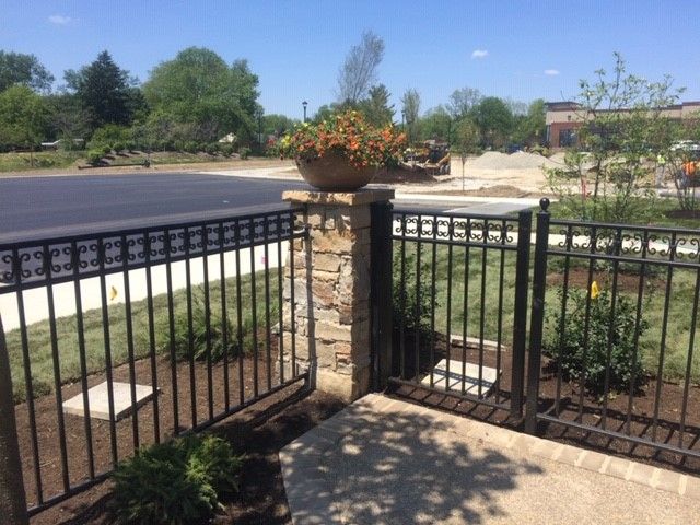A fence with a potted plant on top of it
