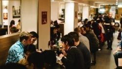 A Group Of People Are Sitting At Tables In A Restaurant — The Garis Group In Hamilton, NSW A Group Of People Are Sitting At Tables In A Restaurant — The Garis Group In Hamilton, NSW