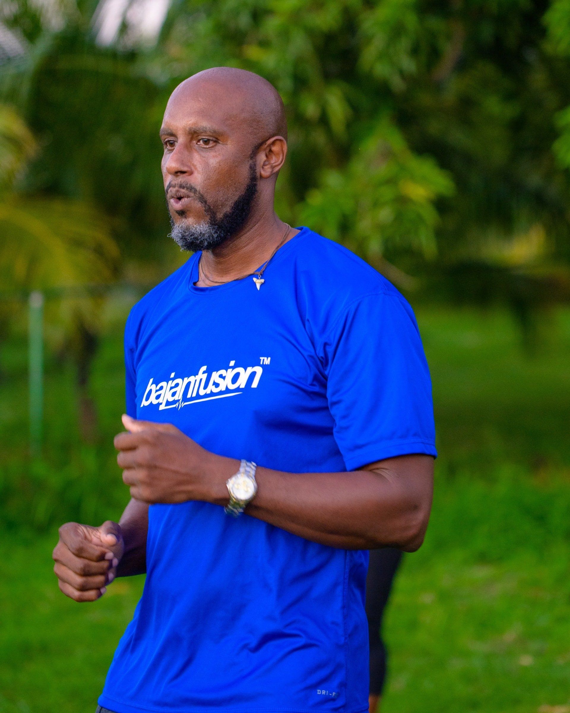 A man wearing a blue shirt that says Bajan fusion