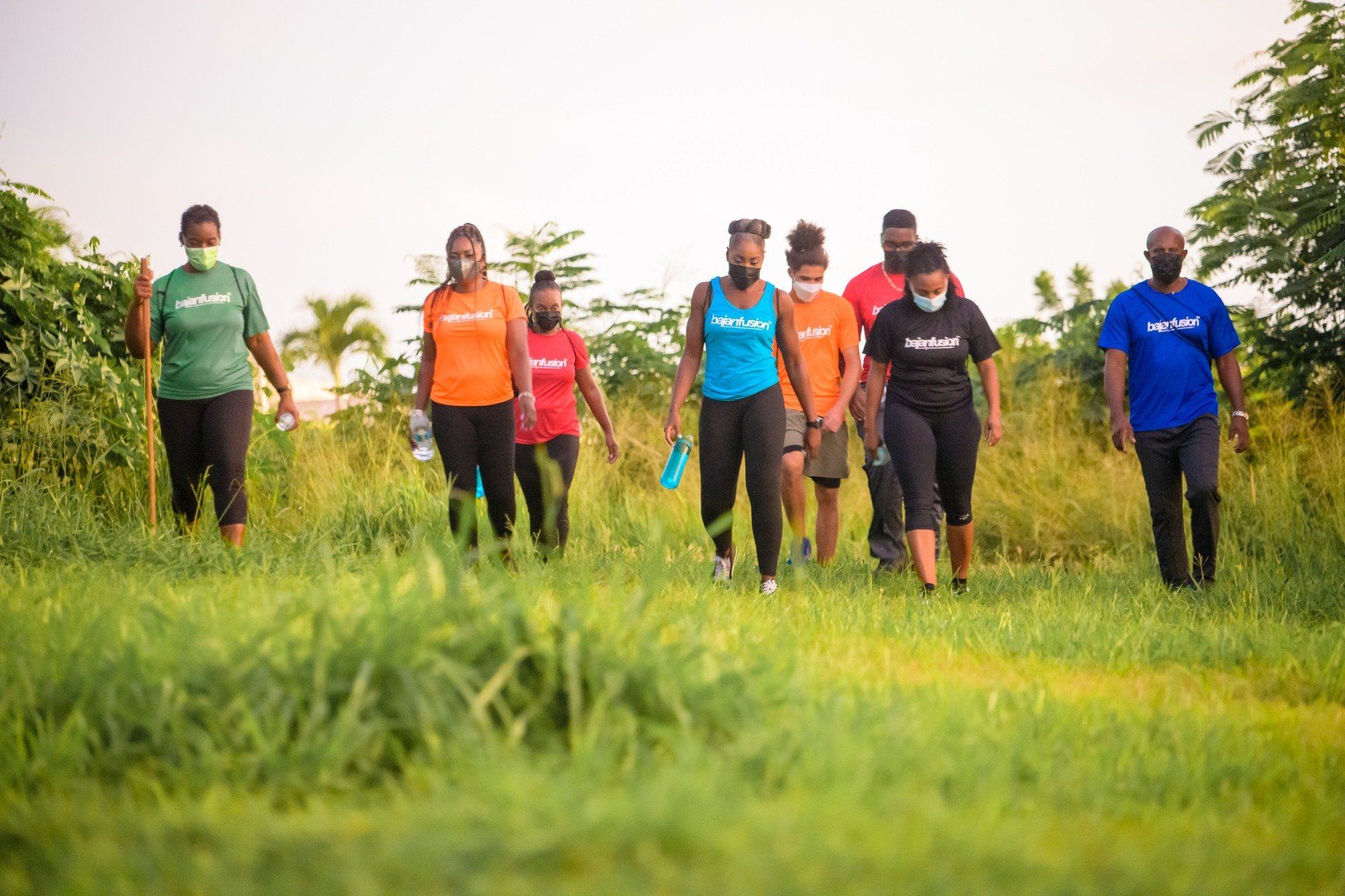 A group of people are walking through a grassy field.