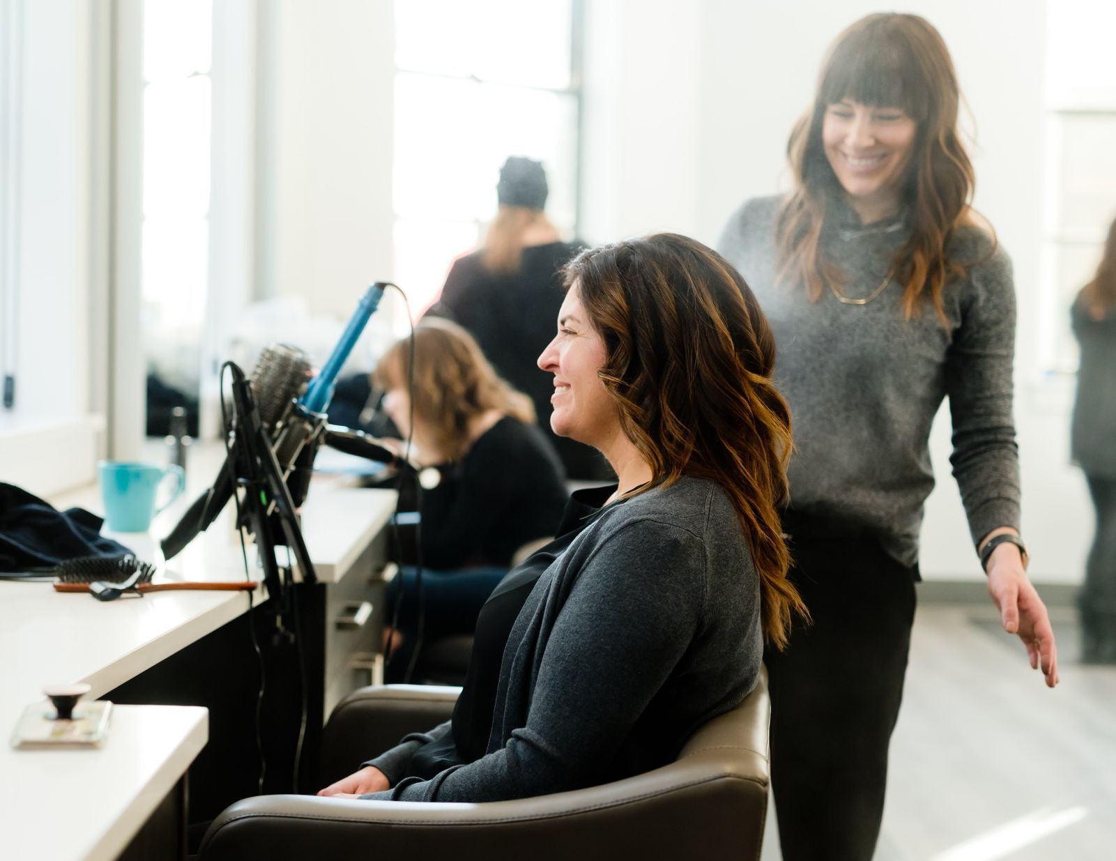 a woman is getting her hair blow dried by a hairdresser