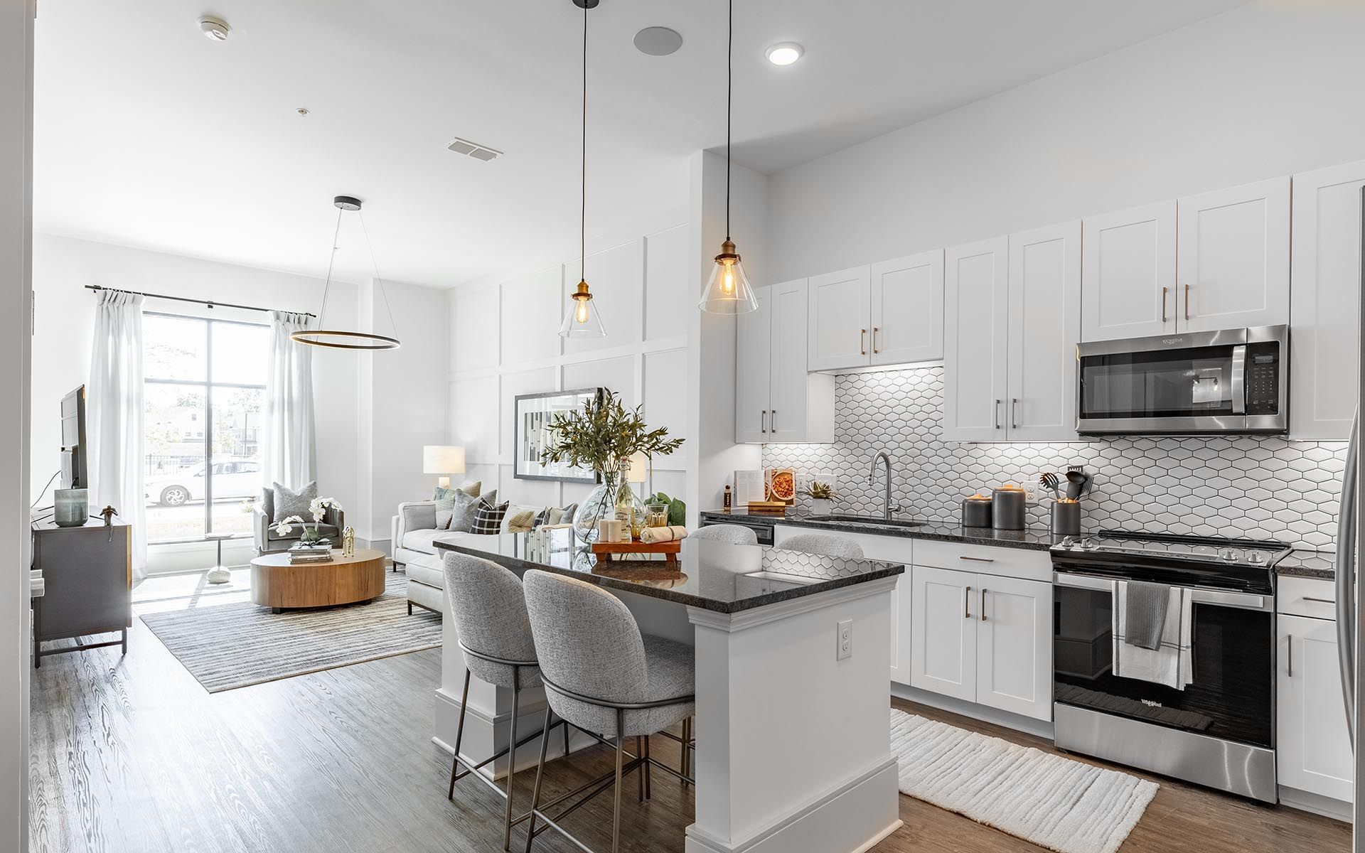 A kitchen in a house with white cabinets and stainless steel appliances.