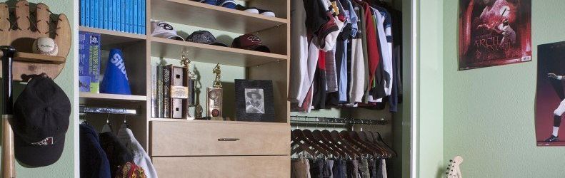 A closet filled with lots of clothes and posters on the wall.