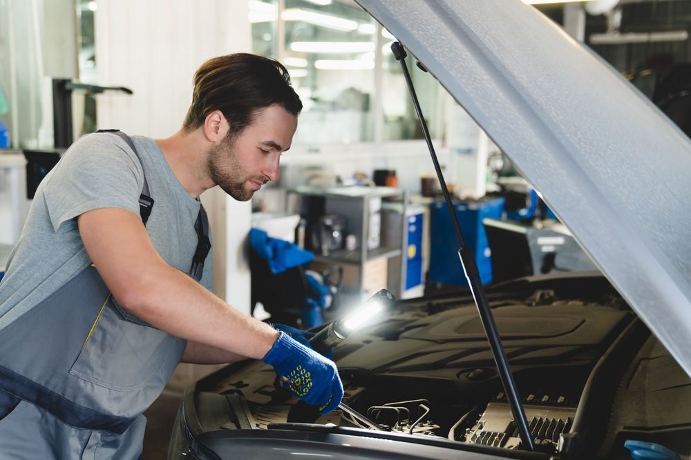 A Man is Working on the Engine of a Car in a Garage — Hive Mobile Roadworthy in Currumbin, QLD