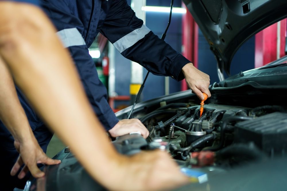 Mechanic Using a Tool to Inspect a Car Engine in a Garage — Hive Mobile Roadworthy in Currumbin Waters, QLD