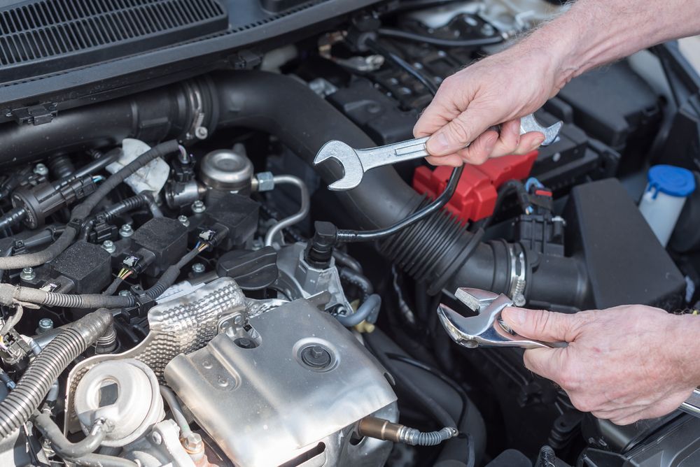 Hands Using a Wrench to Work on a Car Engine — Hive Mobile Roadworthy in Ashmore, QLD