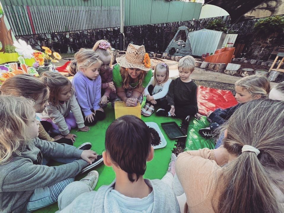A woman is taking a picture of a group of children wearing hats