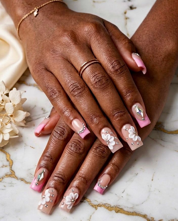 Elegant Pink French Tip Nails with Charming Floral Patterns.