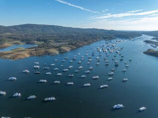 An aerial view of a lake filled with lots of boats.