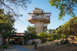 A large building with a tower on top of it is surrounded by trees.