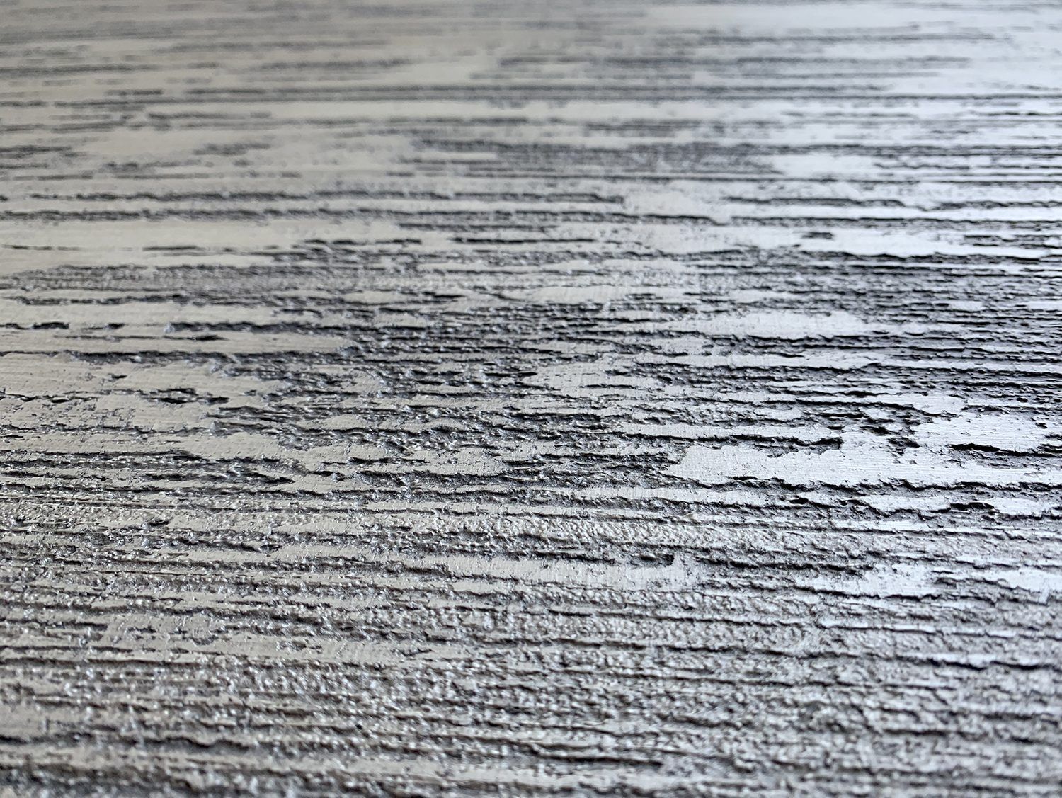Primo piano di venature di legno grigio con striature bianche texturizzate e linee orizzontali scure.