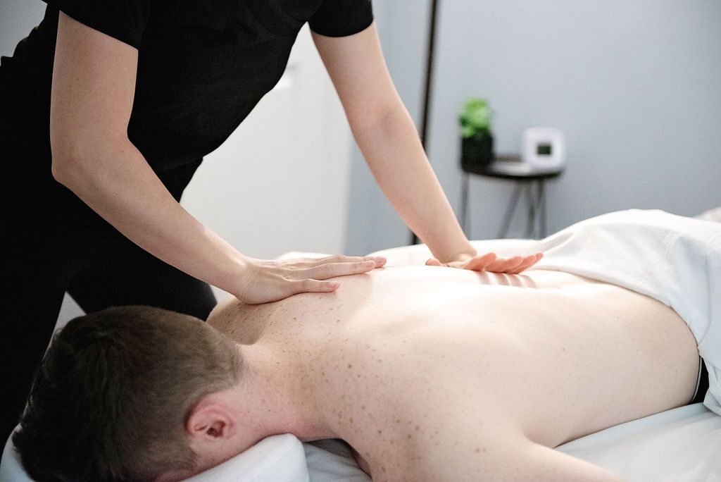 a man is getting a massage from a woman in a black shirt