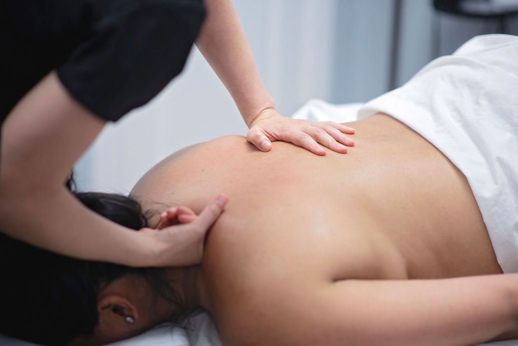 a woman is laying on a table getting a massage