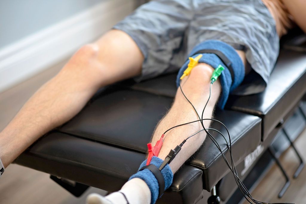 a man is laying on a table with wires attached to his leg