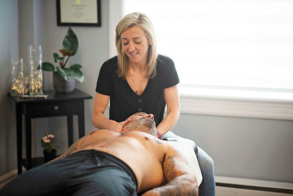 a woman in a black shirt is giving a man a massage