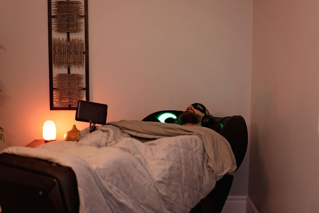 a man is laying in a chair with his eyes closed