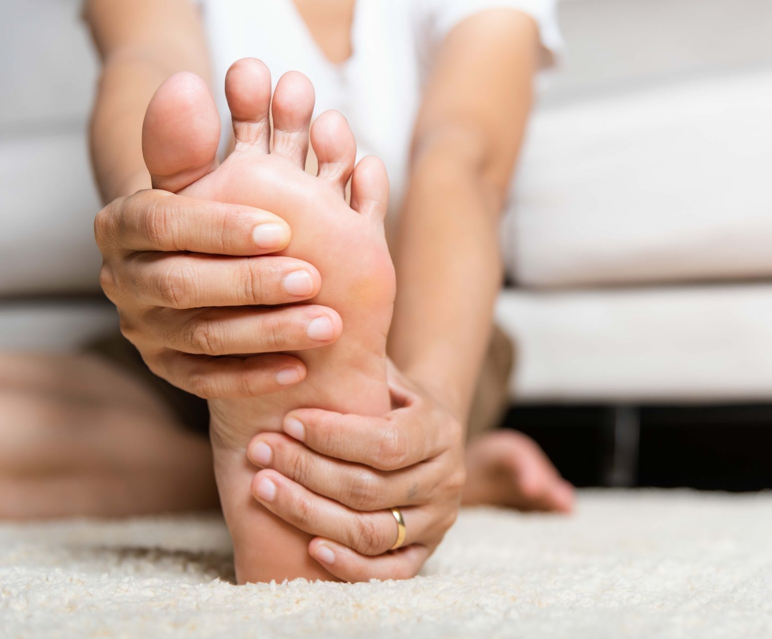 a woman with a ring on her finger is holding her foot