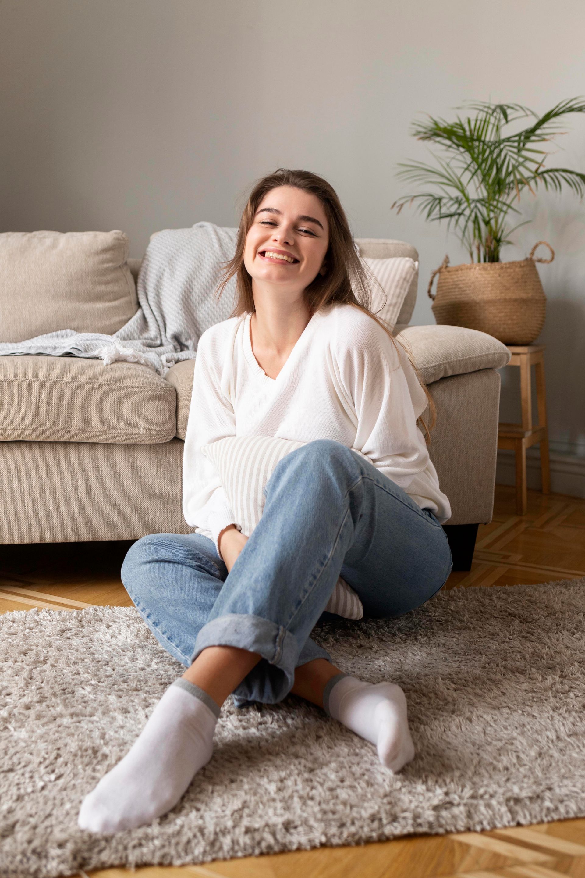 a woman sits on the floor in front of a couch