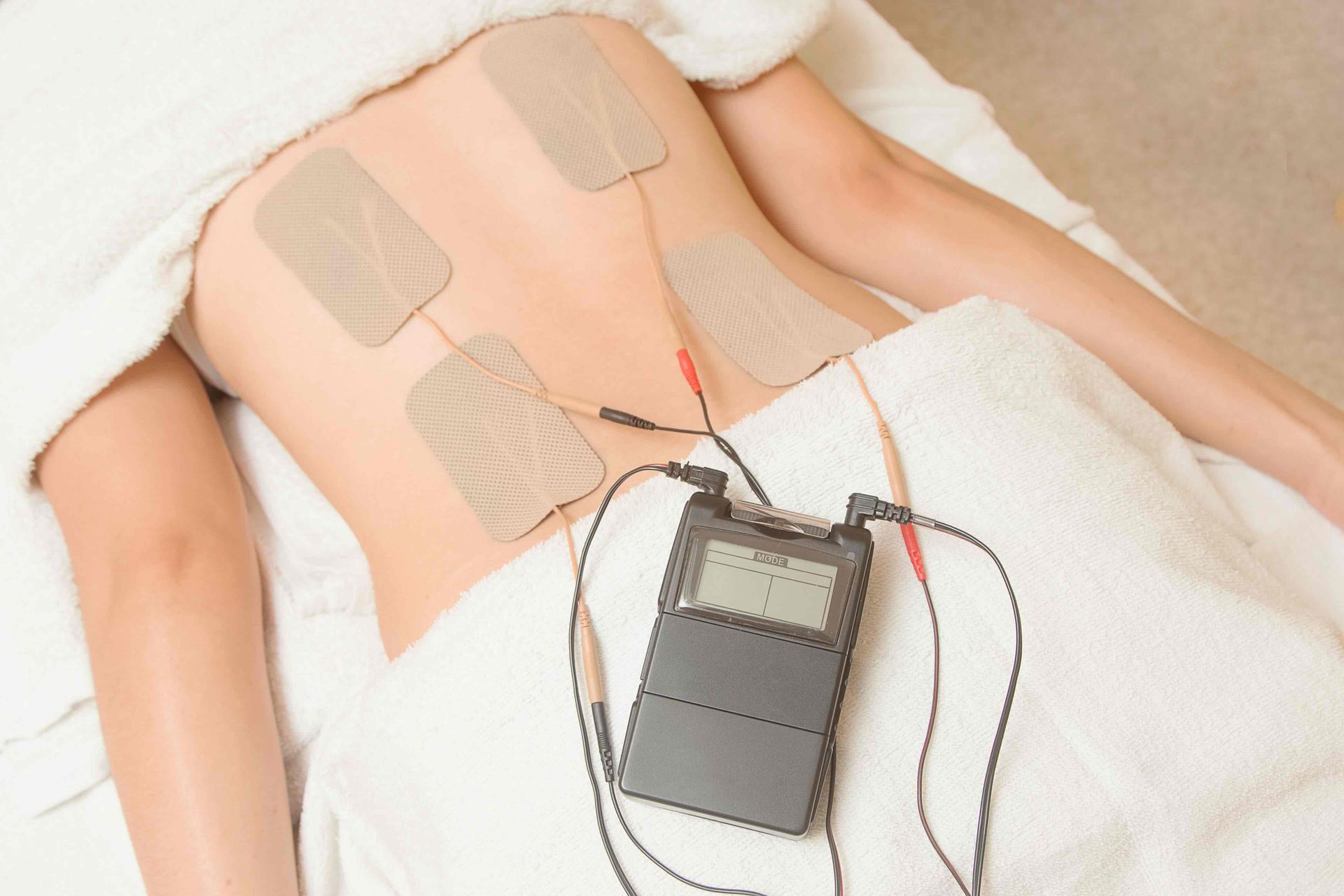 a person laying on a bed with a device on their back