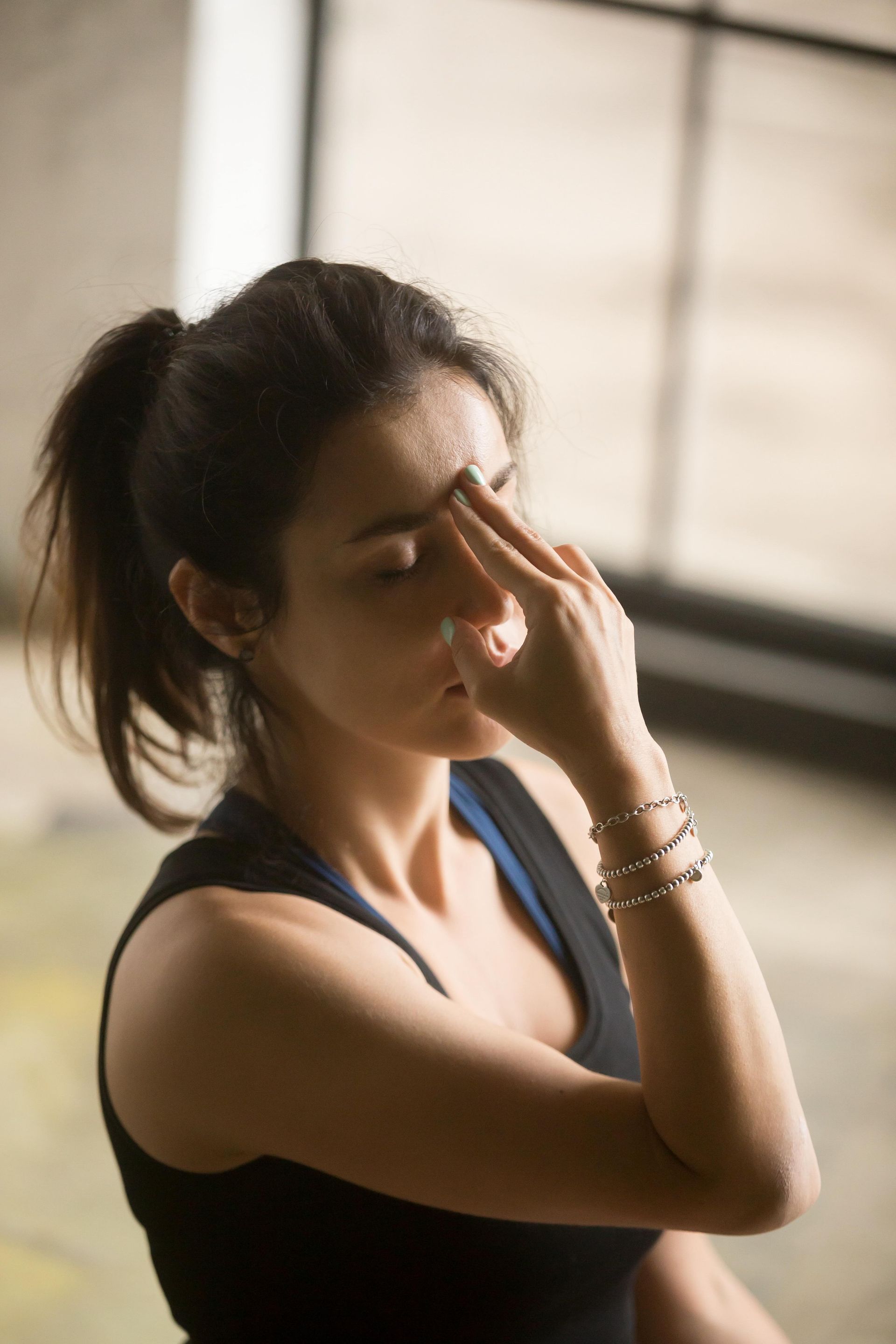a woman with her eyes closed and her hand on her nose
