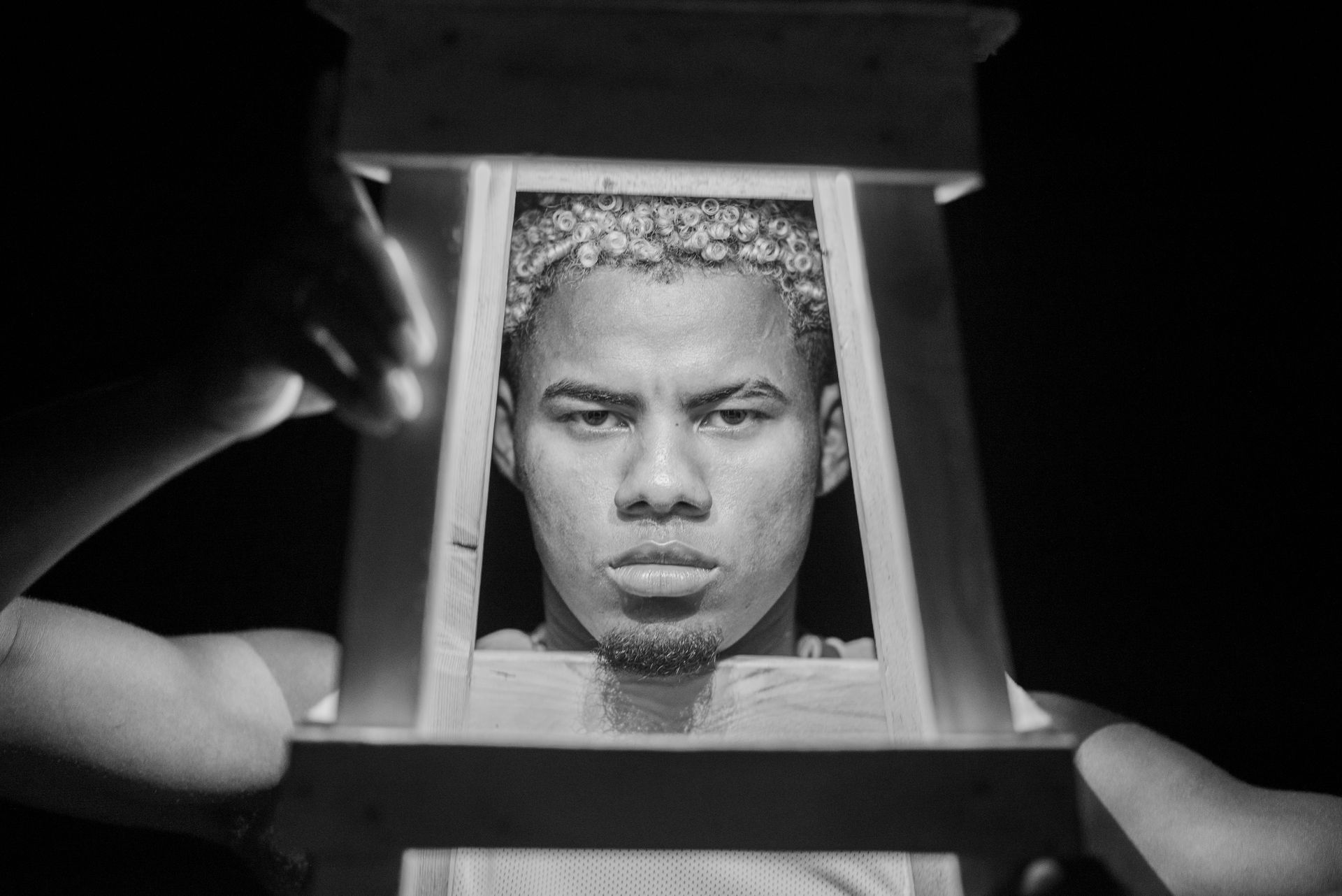 Una fotografía en blanco y negro de la cara de un hombre en una caja.