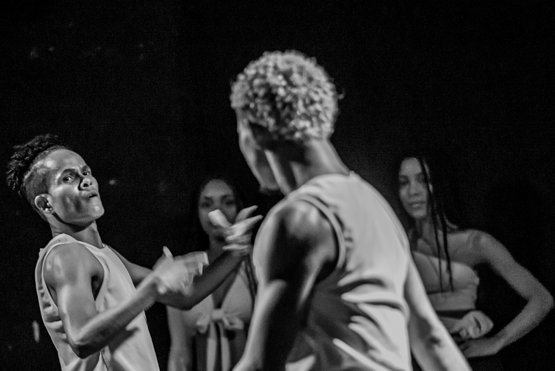 Un grupo de personas bailan juntas en una fotografía en blanco y negro.