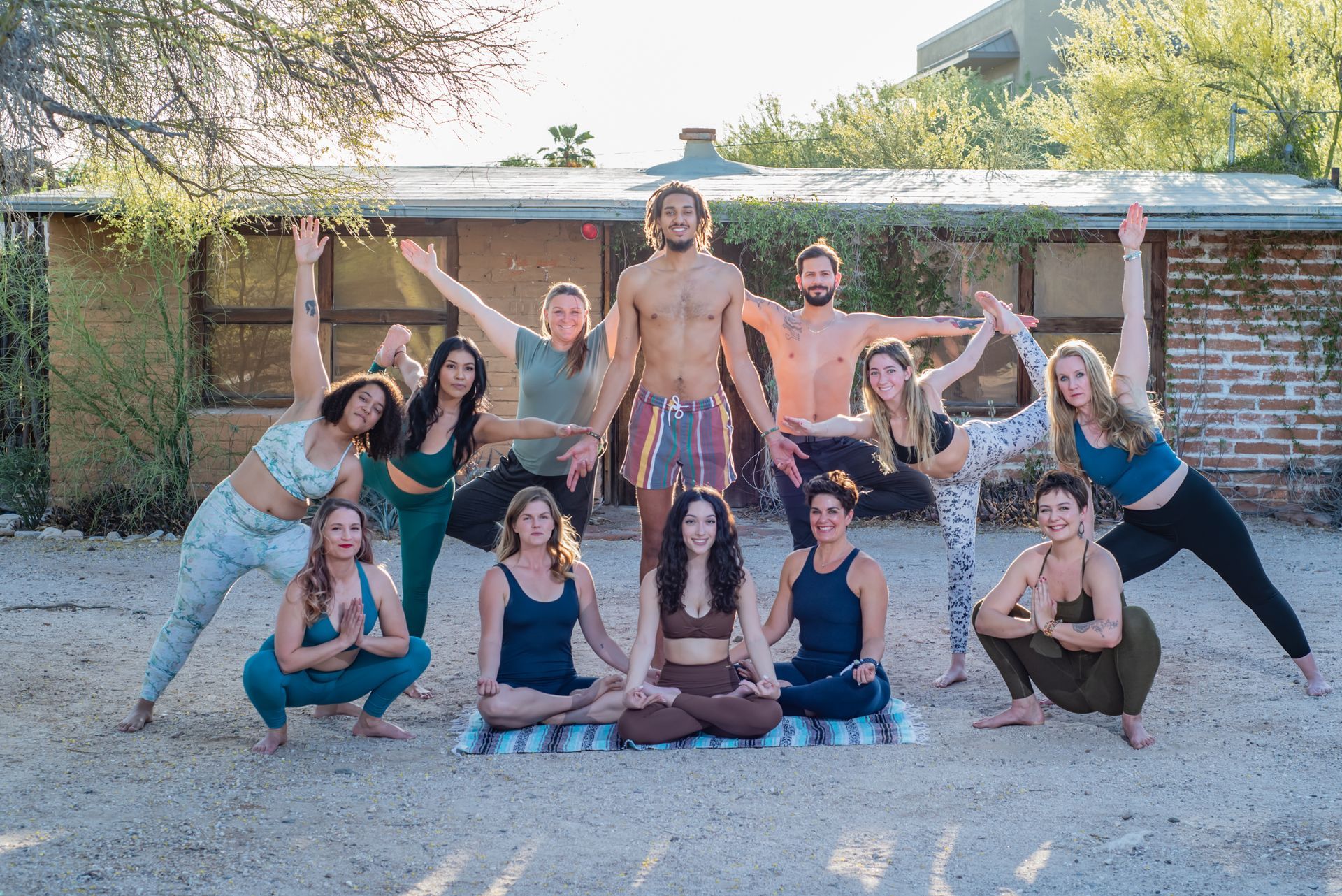 Group of people doing yoga poses outdoors, posing as a sun.