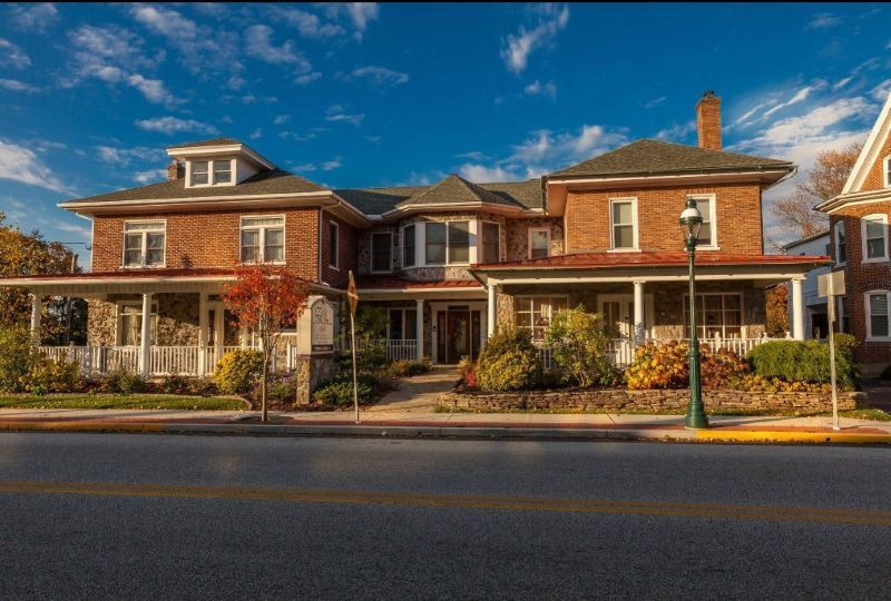 Beautiful exterior of a historic brick building with porch and garden at Quakertown, PA funeral home and cremations.