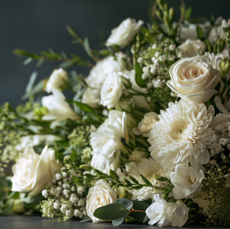 White floral arrangement symbolizing remembrance, compassion, and a meaningful farewell tribute.