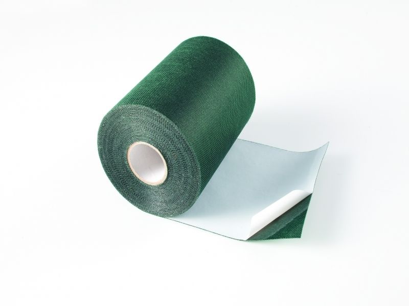 A roll of green tape on a white surface