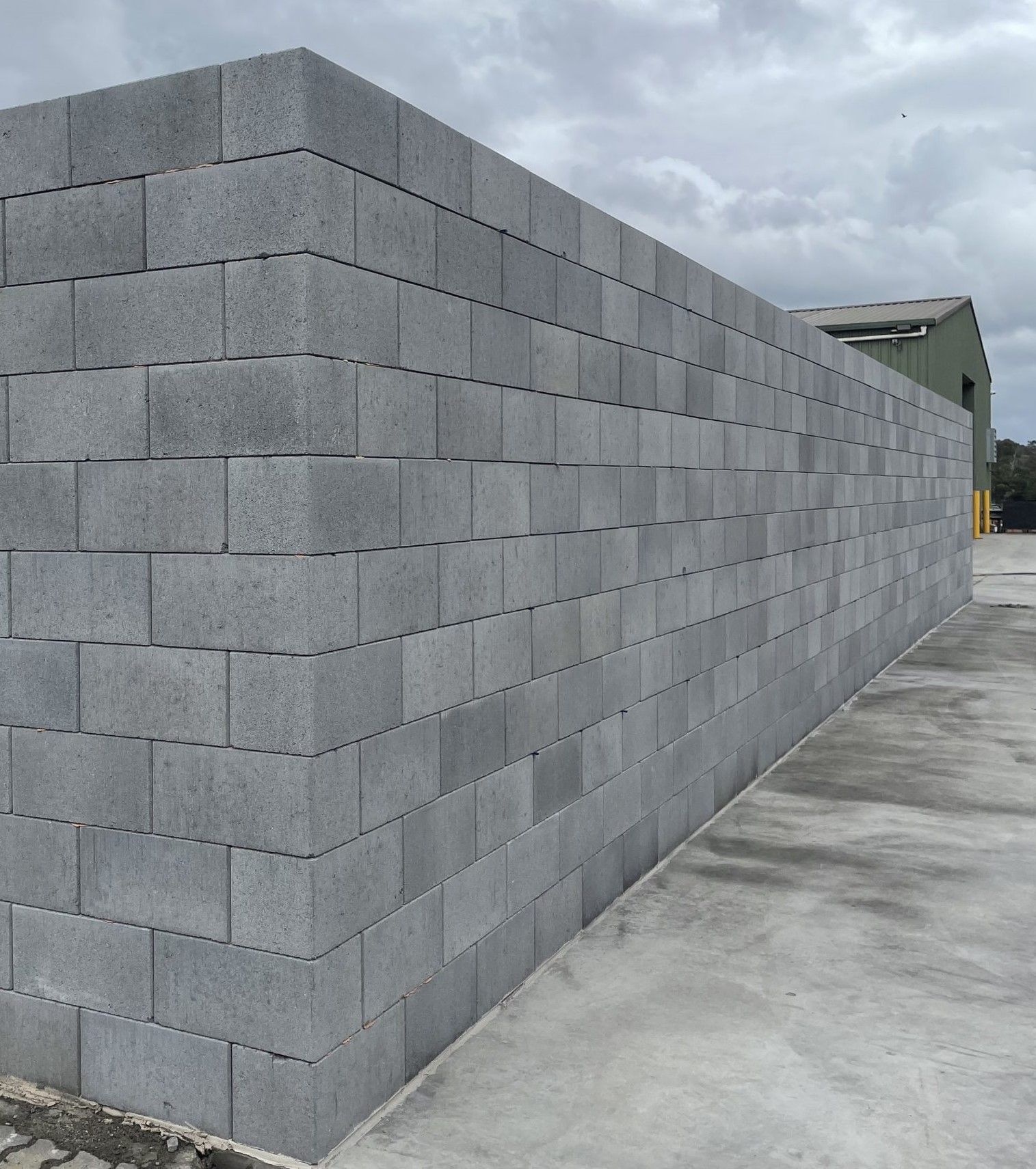 Gray cinder block wall in an outdoor setting.