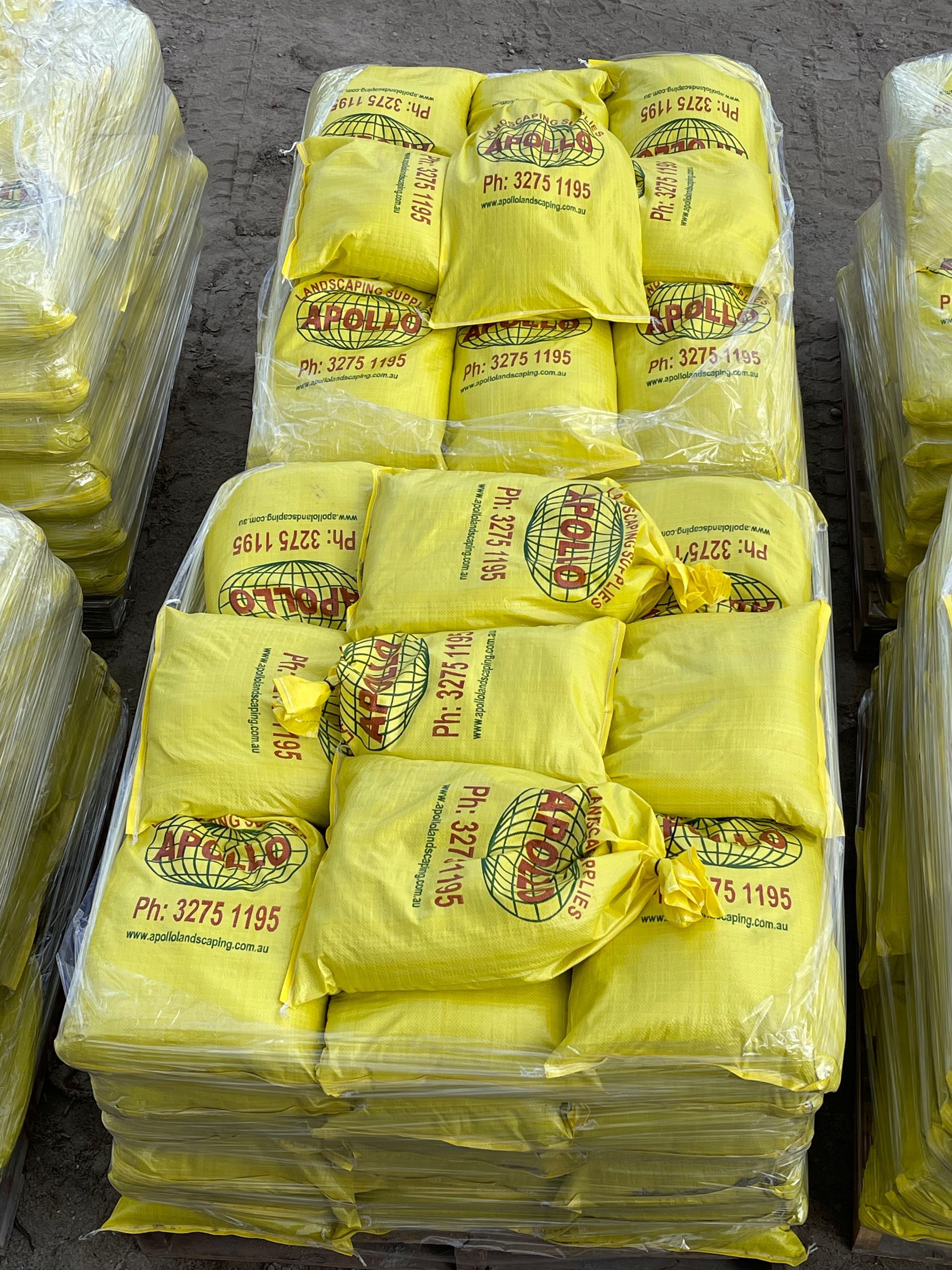 Yellow bags of produce stacked and wrapped in clear plastic.