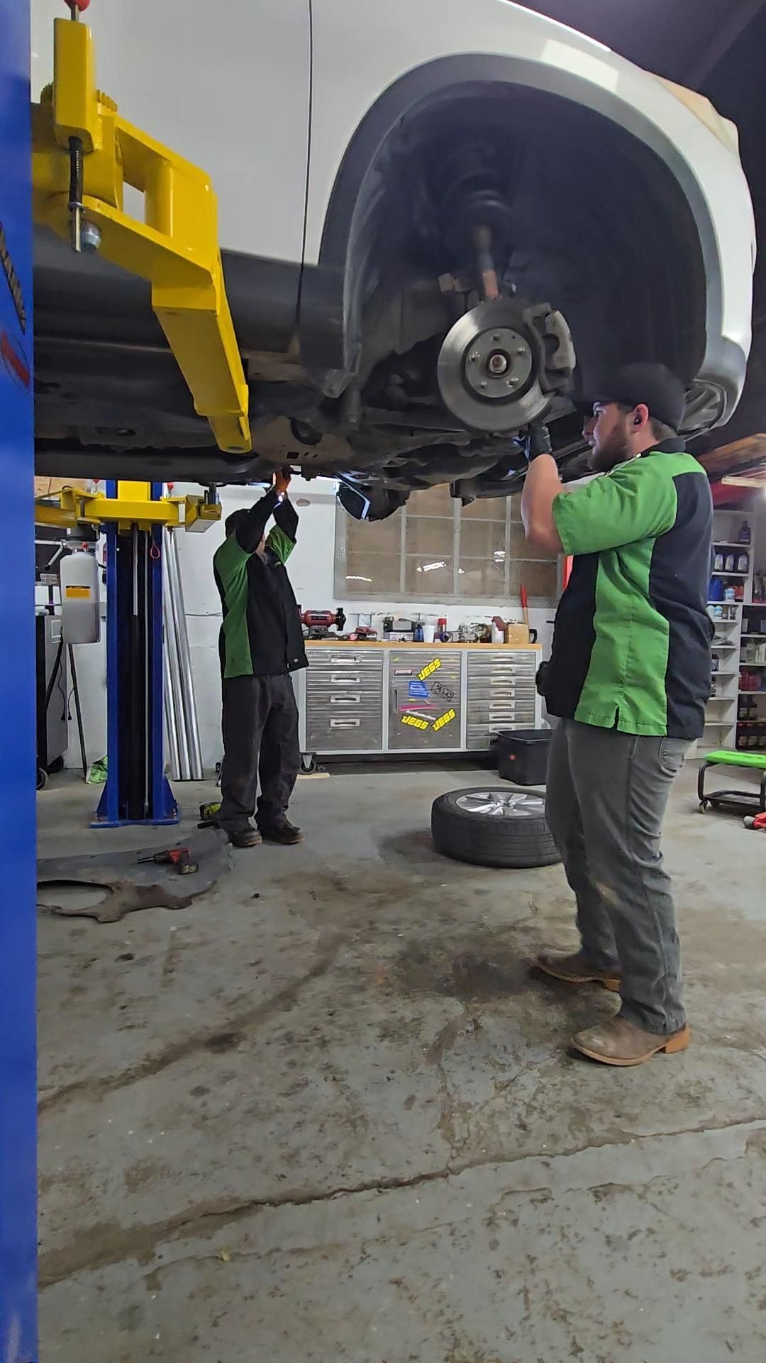 Mechanic Inspecting Wheel Area On Lifted Vehicle | Burnout Boyz Garage LLC