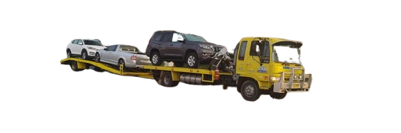 A tow truck is carrying three cars on a flatbed trailer.