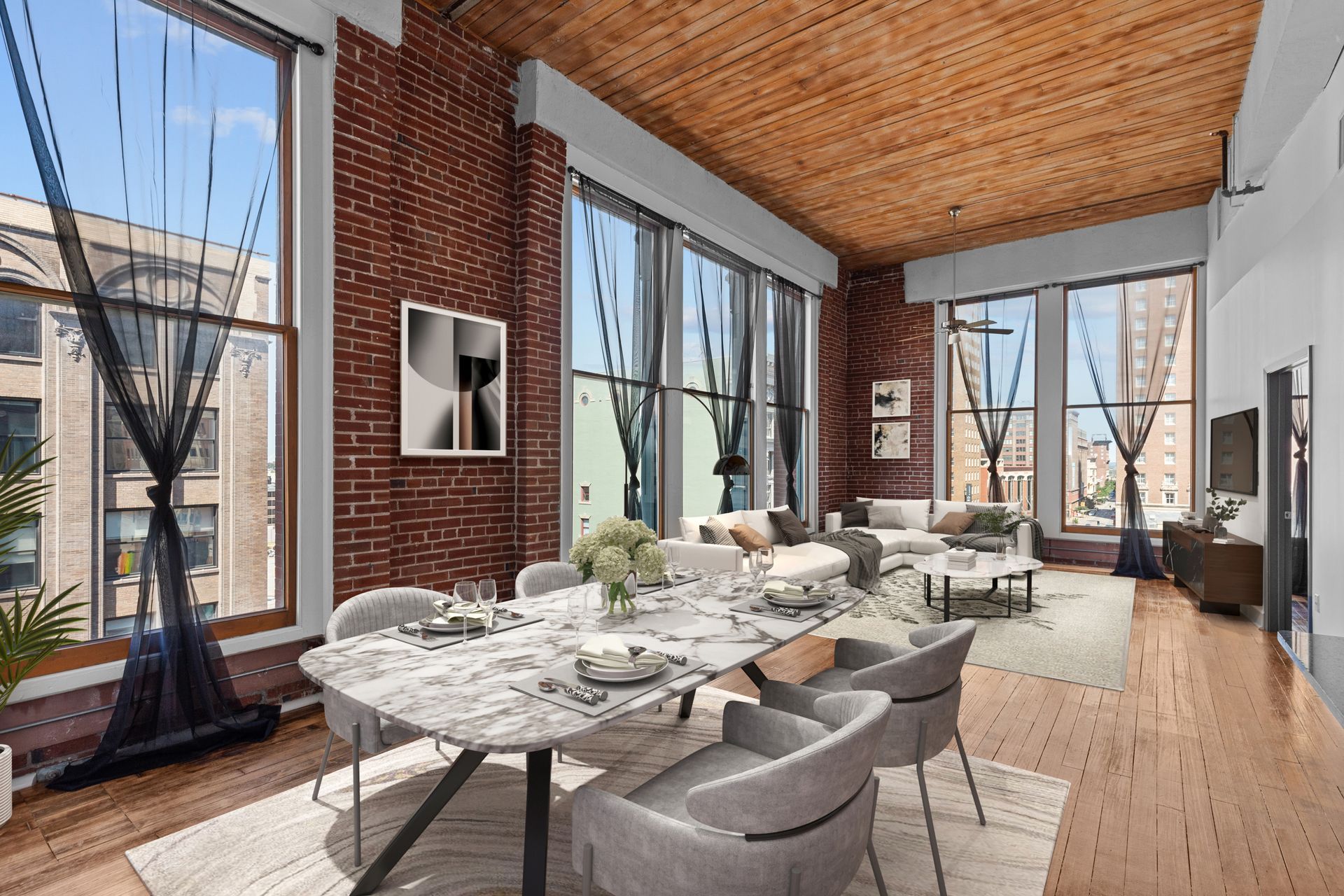Modern dining room with brick walls, large windows, long marble table, and neutral chairs under a wood ceiling