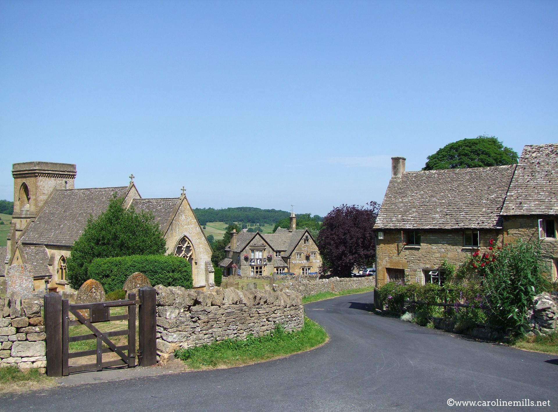 The small village of Snowshill  with a stone wall and a gate
