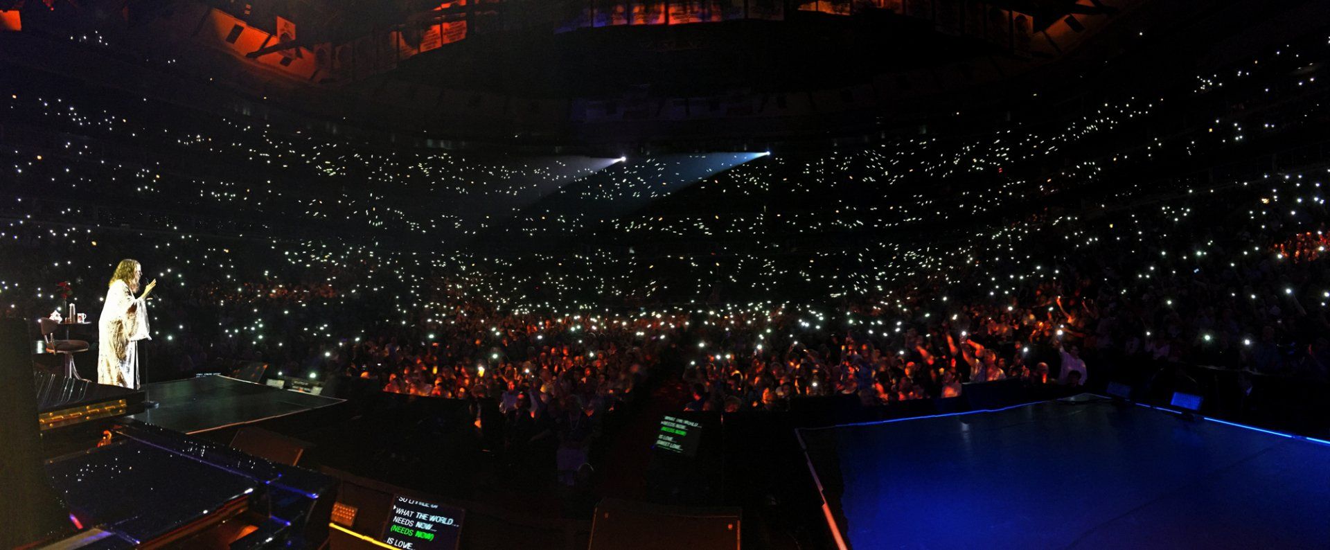 Streisand in front of the Chicago audience with cell phones lit up.