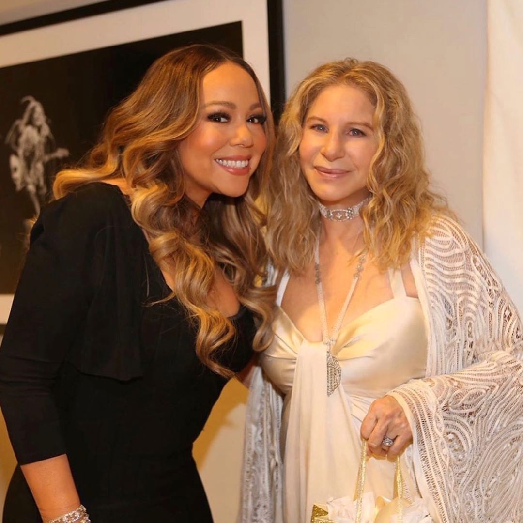 Candid shot backstage of Mariah Carey and Barbra Streisand.