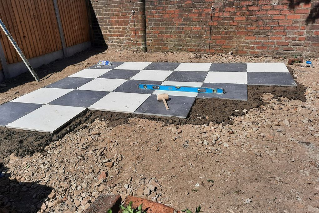 Black and white porcelain tiles being laid in a chequerboard pattern in Kirkstall