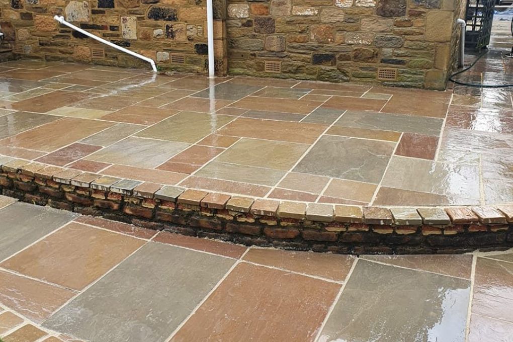 Stepped Indian stone patio against a stone house wall in Kirkstall